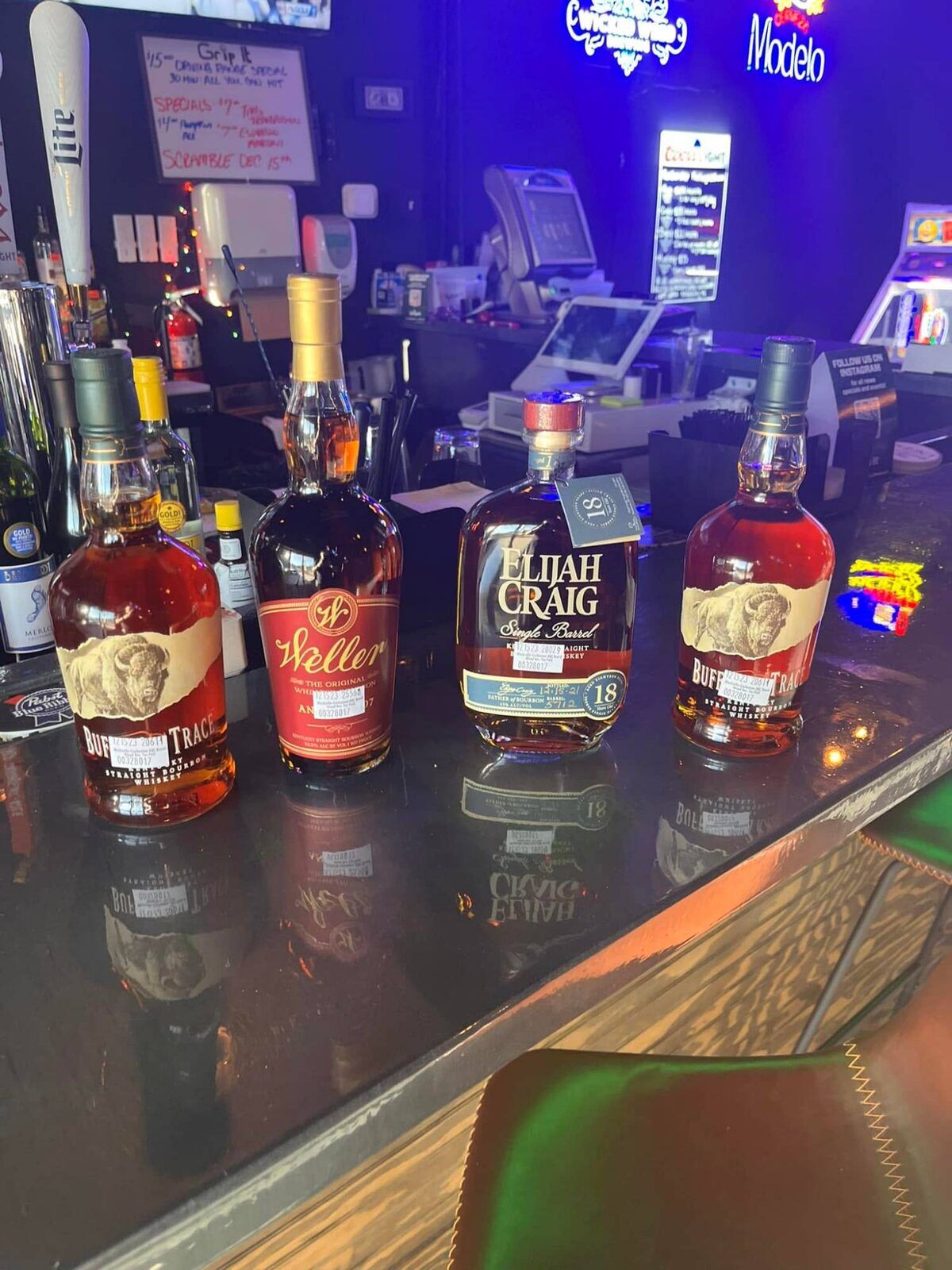 Bourbon bottles lined up on the bar at Grip It Virtual Golf